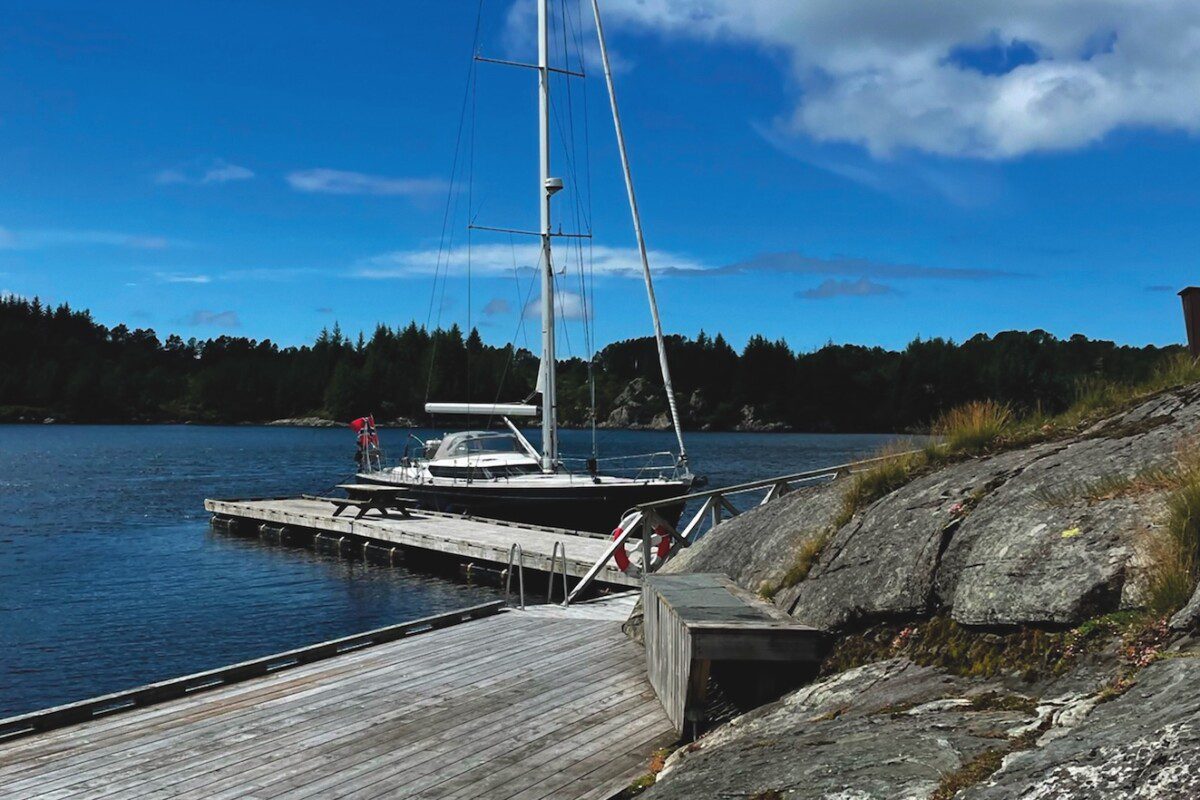 Blue hulled sailing yacht tied up to an isolated dock