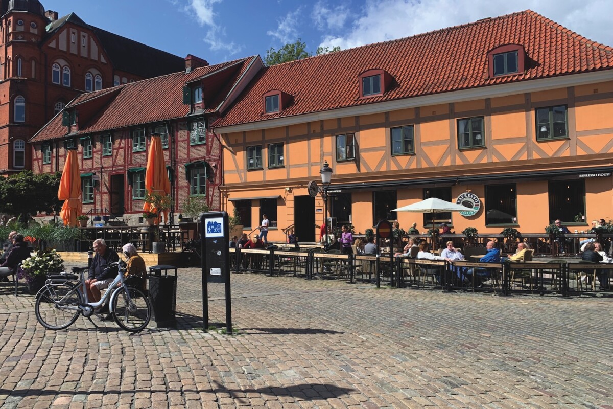 Traditional Swedish building with orange cladding and red tiled roof with tables and benches outside