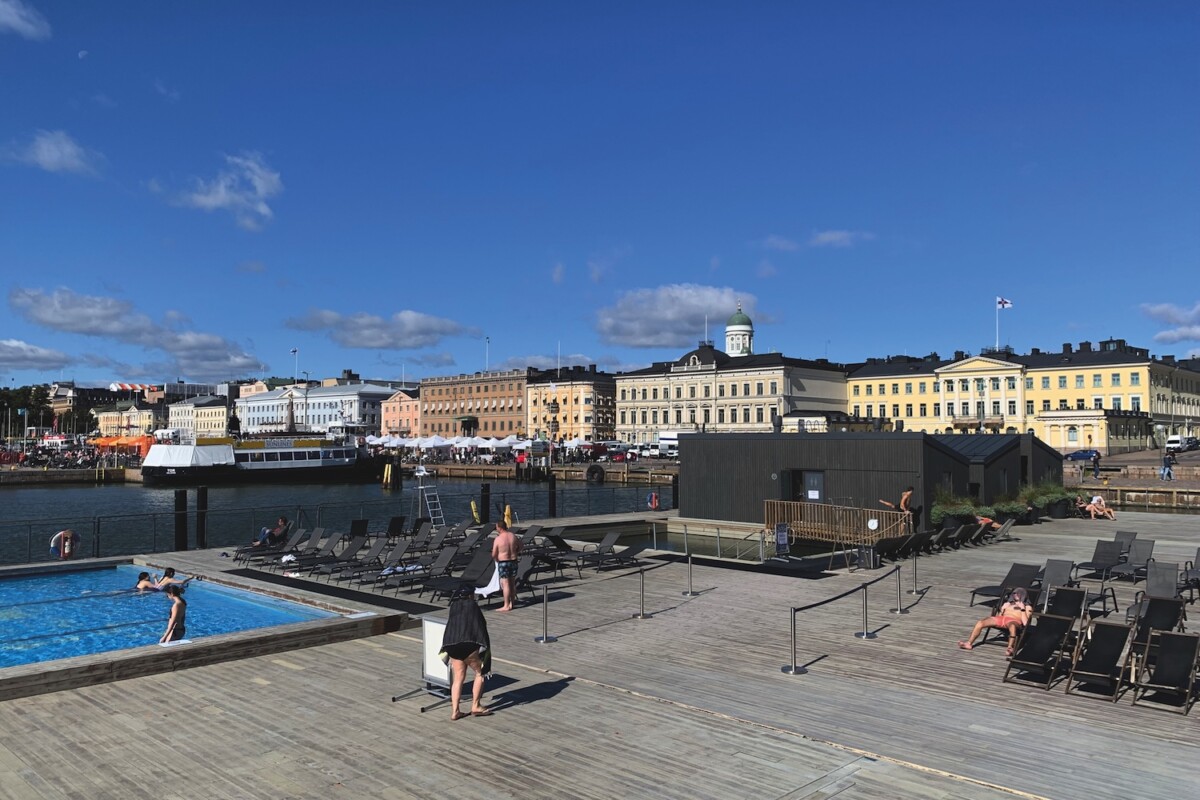 Swimming pool and sauna on the edge of a harbour with a passenger ferry in the distance